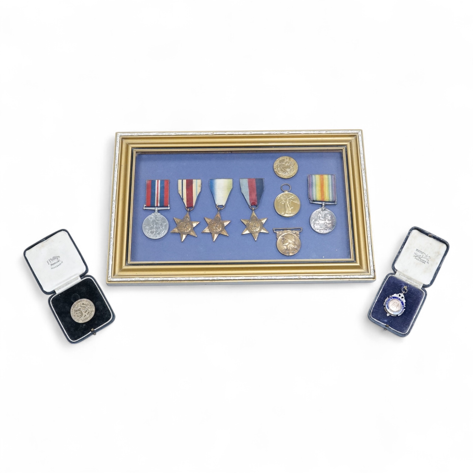 Framed group of eight WWI and WWII medals including a First World War medal pair, the Africa star, the Atlantic star, etc. a hallmarked silver boxing medal and another, both cased, plus a Lancashire and Cheshire Associat